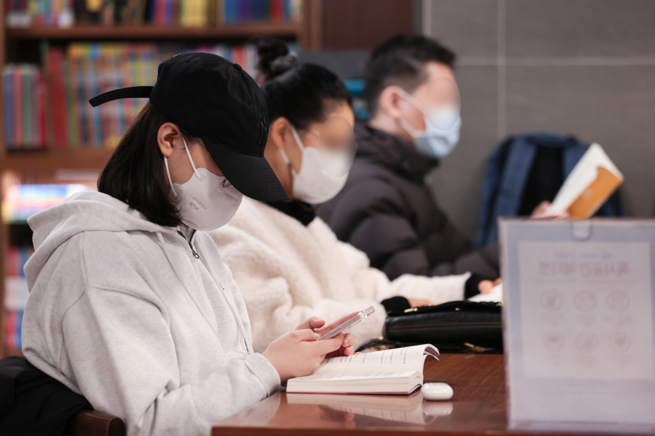 국가감염병위기대응자문위원회 실내마스크 착용 의무 조정 논의를 하루 앞둔 16일 시민들이 서울 시내 한 대형서점에서 마스크를 착용하고 책을 읽고 있다. 정기석 국가감염병위기대응자문위원장은 16일 브리핑에서 "이번 겨울 코로나19 유행이 정점을 지나고 이제는 안정된 상황으로 진입하고 있다"며 실내마스크 착용 의무와 관련해 "해제가 멀지 않았다"고 발언했다. 한편 이날 신규확진자는 1만4144명으로 12주만에 최소치를 기록했다. [연합]