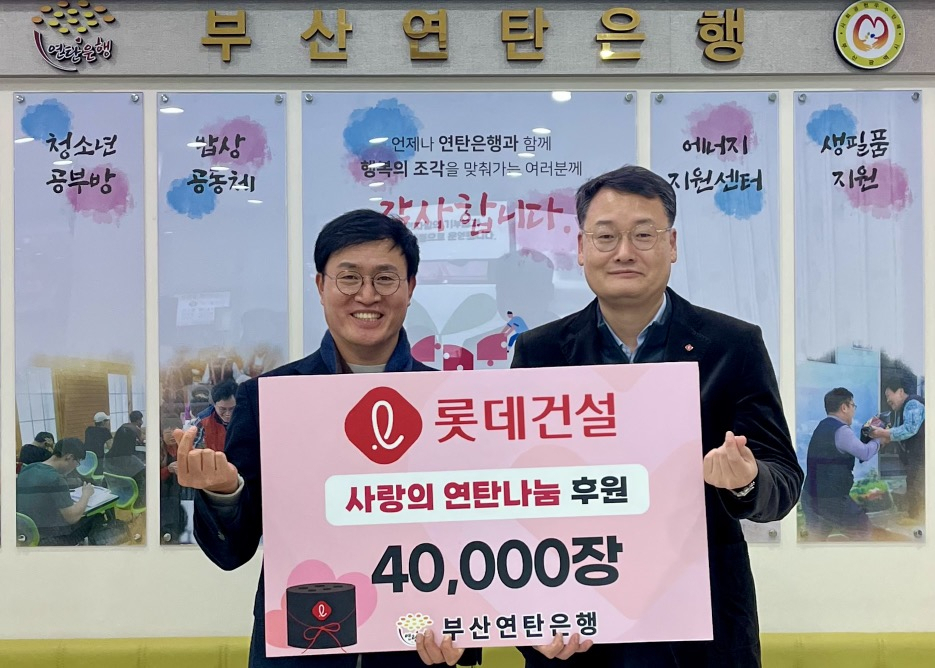 윤수준 롯데건설 영남지사장(오른쪽)과 강정칠 부산연탄은행 대표(왼쪽)가 ‘사랑의 연탄나눔’ 전달식에 참여해 기념사진을 촬영하고 있다. [롯데건설 제공]