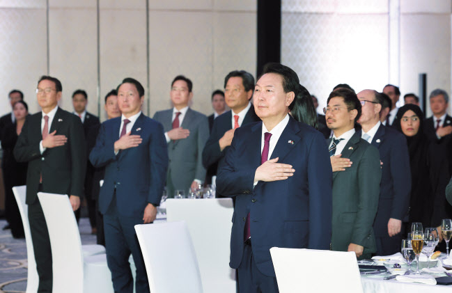 윤석열 대통령이 17일(현지시간) 아랍에미리트(UAE) 콘래드 아부다비 에티하드타워에서 열린 동행 경제인과의 만찬간담회에서 국기에 대한 경례를 하고 있다. 윤 대통령은 UAE 국빈방문에 이어 다보스포럼으로 불리는 세계경제포럼(WEF) 연차총회 참석을 위해 스위스로 이동한다. [연합]