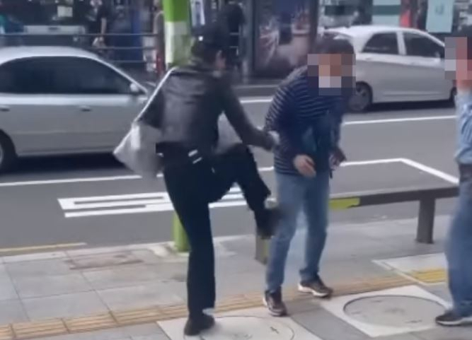 지난해 9월 26일 서울 강북구 수유역 인근 거리에서 20대 여성이 흡연을 단속하던 70대 공무원을 폭행하고 있다. [온라인 커뮤니티 캡처]