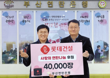 윤수준(오른쪽) 롯데건설 영남지사장과 강정칠(왼쪽) 부산연탄은행 대표가 ‘사랑의 연탄나눔’ 전달식에 참여해 기념사진을 촬영하고 있다. [롯데건설 제공]