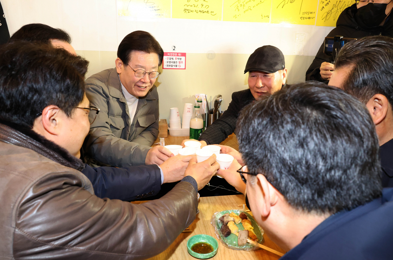 이재명 더불어민주당 대표가 18일 설 명절을 앞두고 서울시 마포구 망원시장 한 식당에서 시민들과 막걸리로 건배하고 있다. [연합]