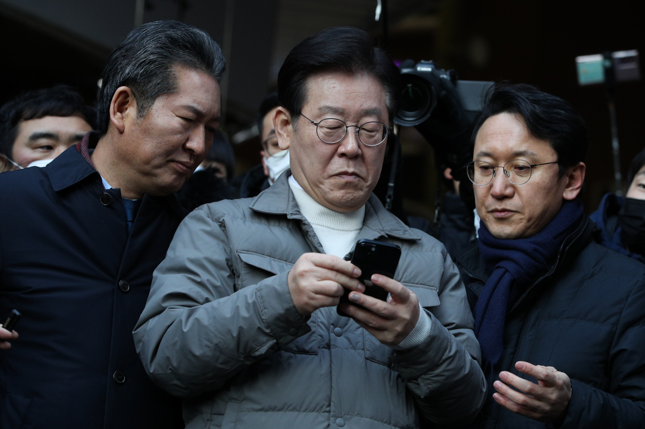 이재명 더불어민주당 대표가 18일 오후 설 명절을 앞두고 서울시 마포구 망원시장을 방문, 시장 상인들을 만난 뒤 검찰 소환에 대한 입장을 밝히기 전 핸드폰을 보고 있다. [연합뉴스]