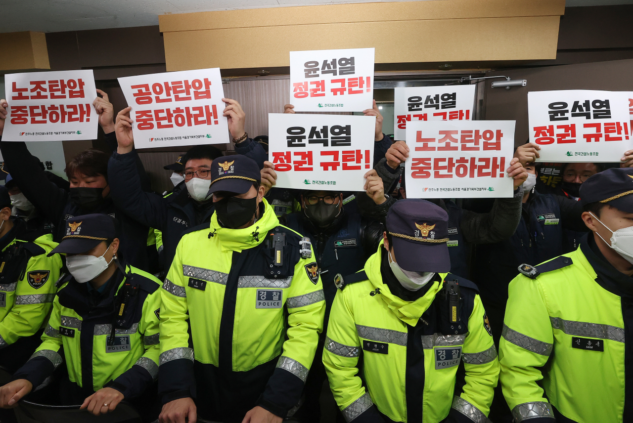 Members of the Korean Confederation of Trade Unions' construction union hold signs in front of its office in Yeongdeungpo-gu, Seoul, where a search is underway Thursday morning. The signs read "Stop oppression of unions" and "We condemn the Yoon Suk Yeol regime."
