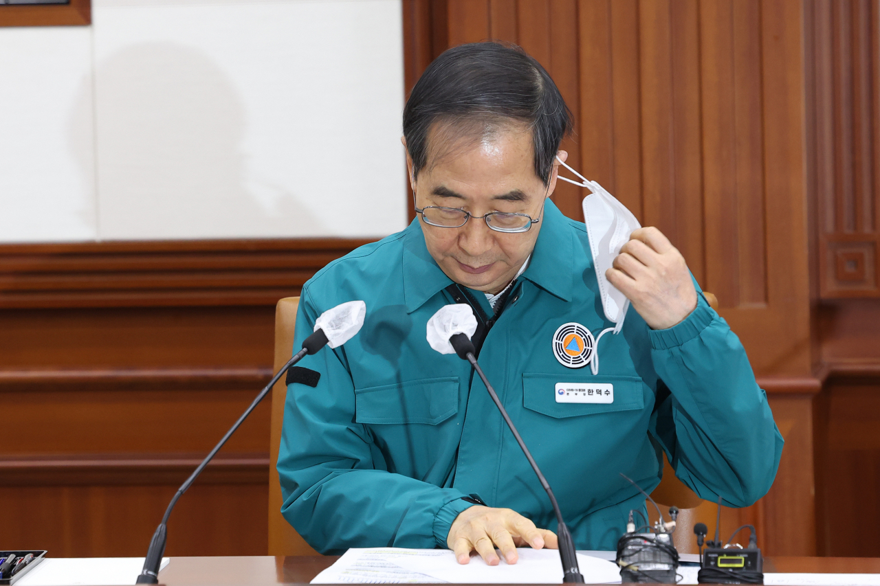 한덕수 국무총리가 20일 오전 정부서울청사에서 열린 코로나19 중앙대책본부 회의에서 마스크를 벗고 있다. [연합]