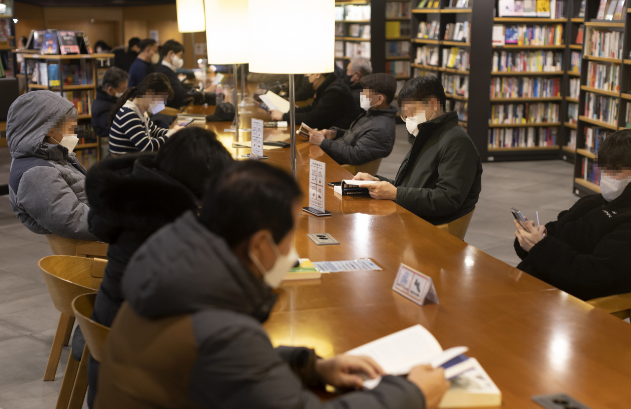 17일 점심시간 서울의 한 서점에서 시민들이 마스크를 쓴 채 책을 읽고 있다. [연합]