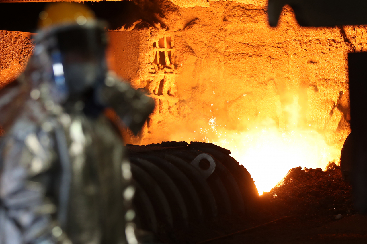 A Posco worker is seen nearby a blast furnace releasing molten iron at Posco’s steel plant in Pohang, North Gyeongsang Province. (Yonhap)