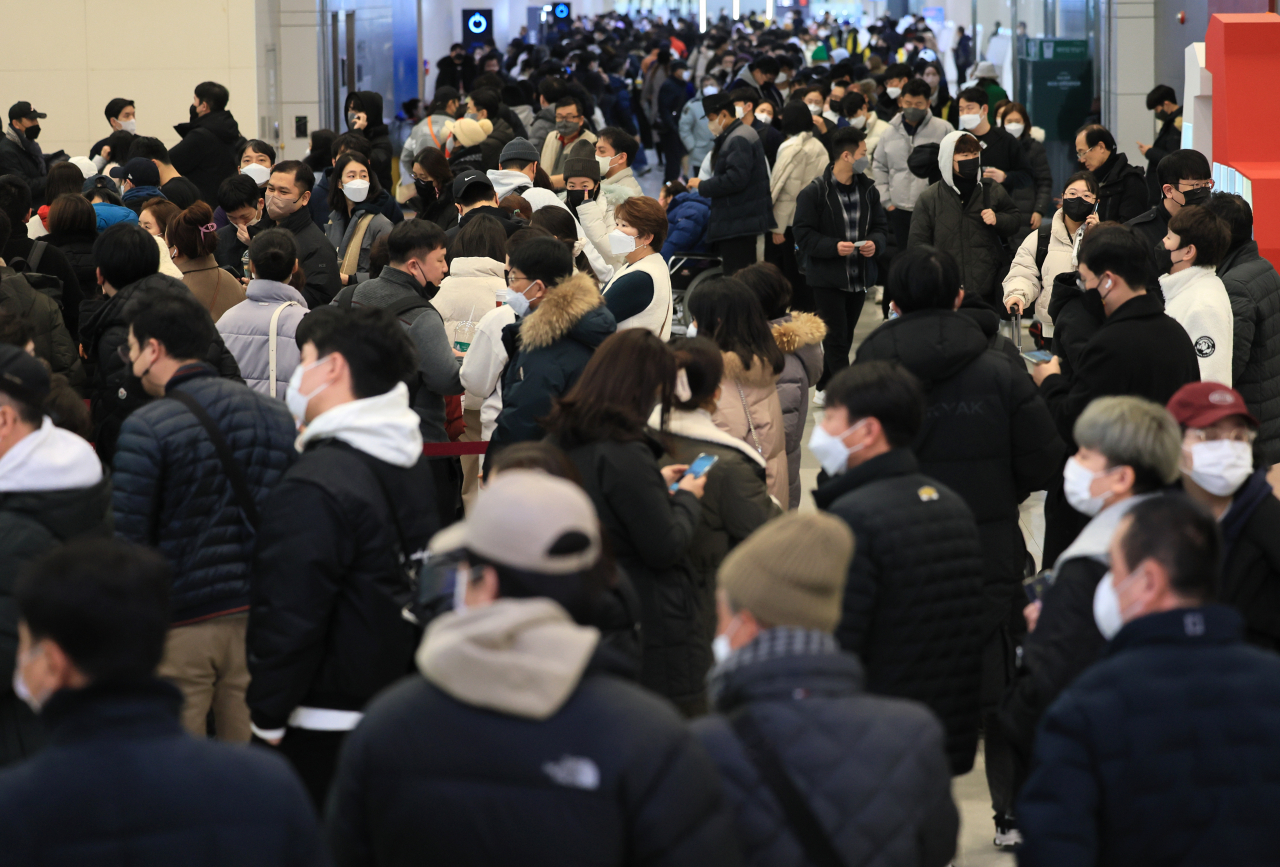 설 연휴 마지막 날인 24일 오전 폭설과 강풍이 몰아쳐 항공편이 전편 결항한 가운데 승객들이 대기표를 구하기 위해 각 항공사 대기전용 카운터에 길게 줄을 서 있다. 연합뉴스