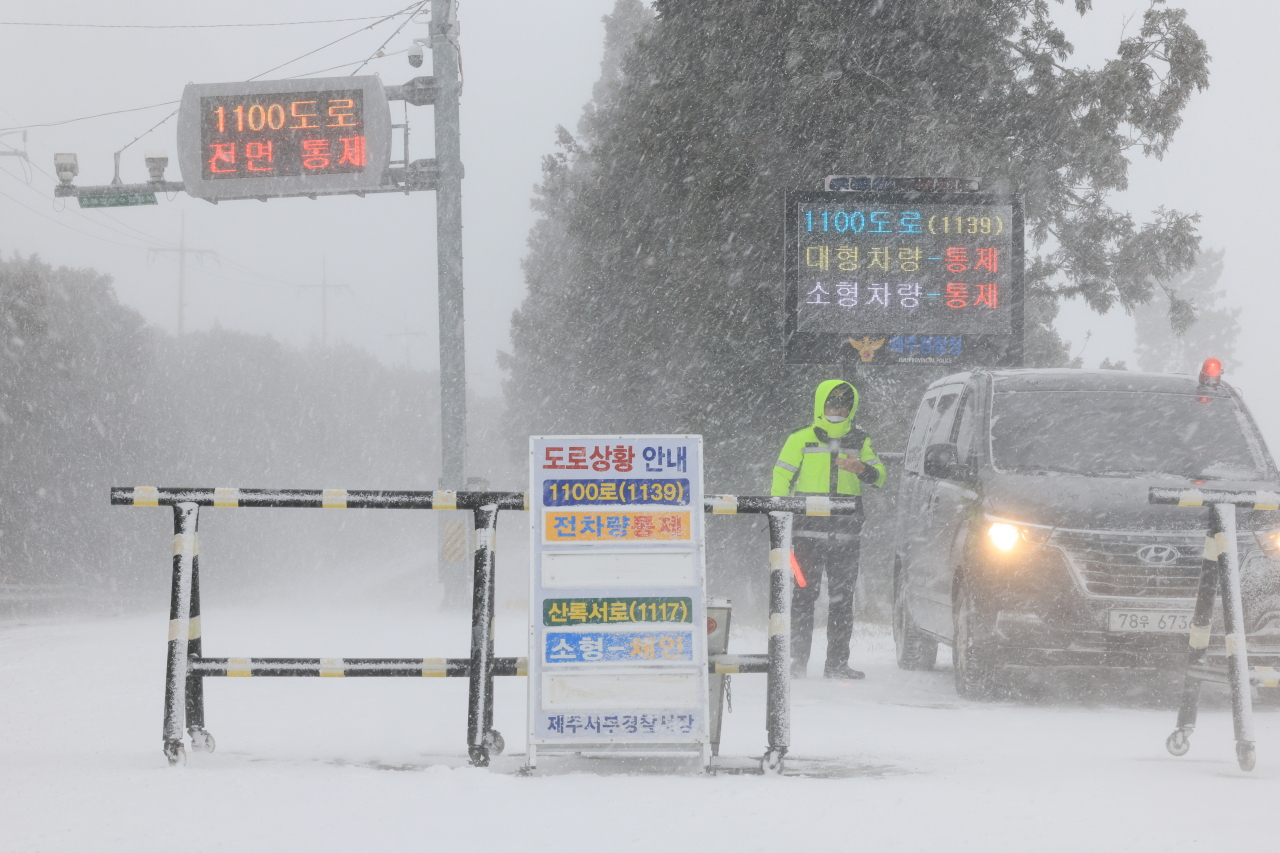 설 연휴 마지막 날이자 폭설이 시작된 24일 오전 제주시 해안동 축산진흥원 앞에서 경찰이 산간도로 출입을 통제하고 있다. 연합뉴스