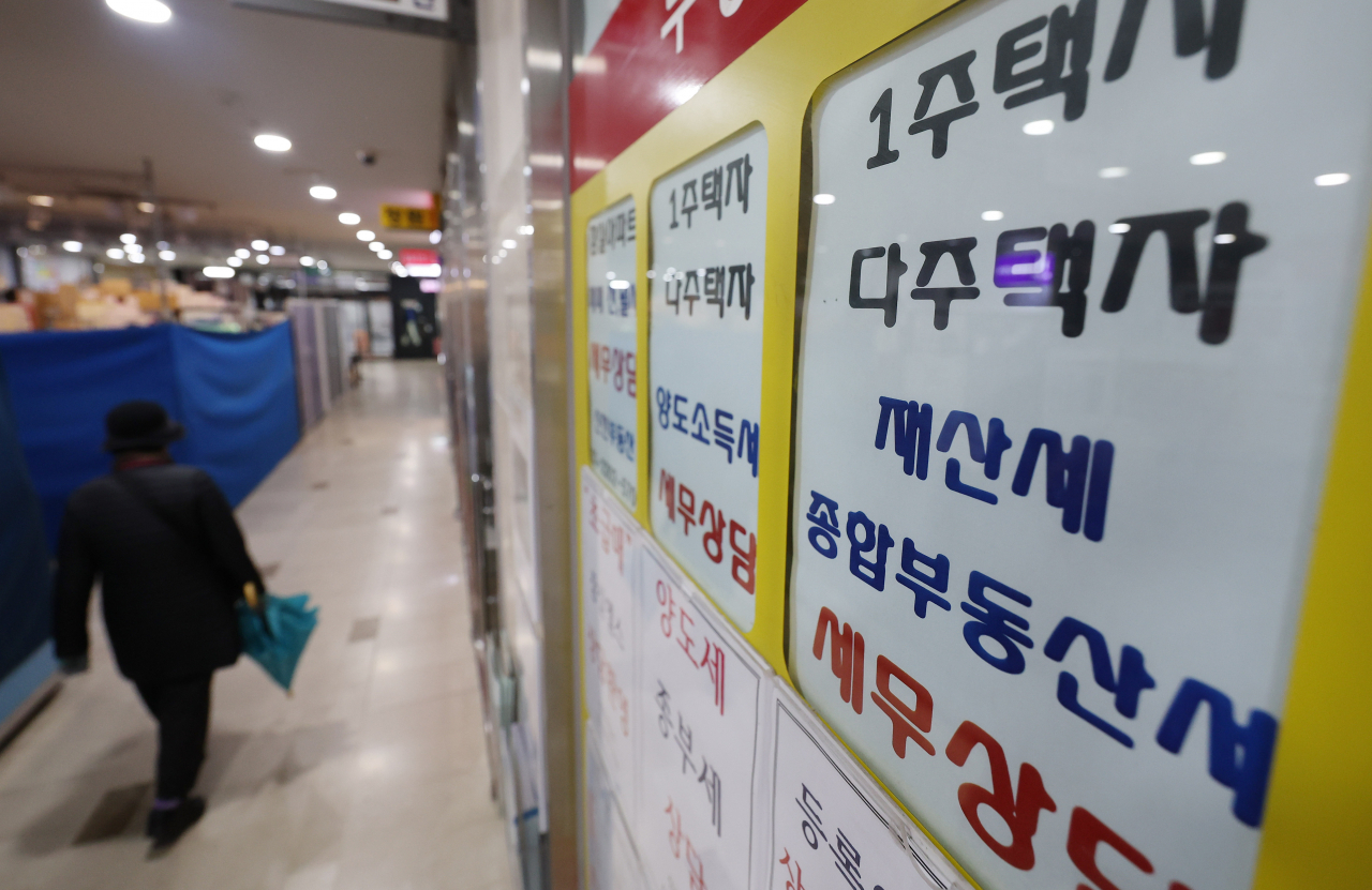 서울 한 부동산중개사무소 앞을 시민이 지나가고 있다.[연합]