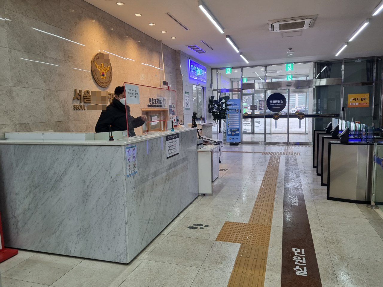 26일 오전 서울 소재 한 경찰서 1층에 한 직원이 두꺼운 점퍼와 목도리를 껴입은 채 근무를 하고 있다. 추위로 인해 해당 경찰관 옆에는 난로가 틀어져 있었다. 김영철 기자