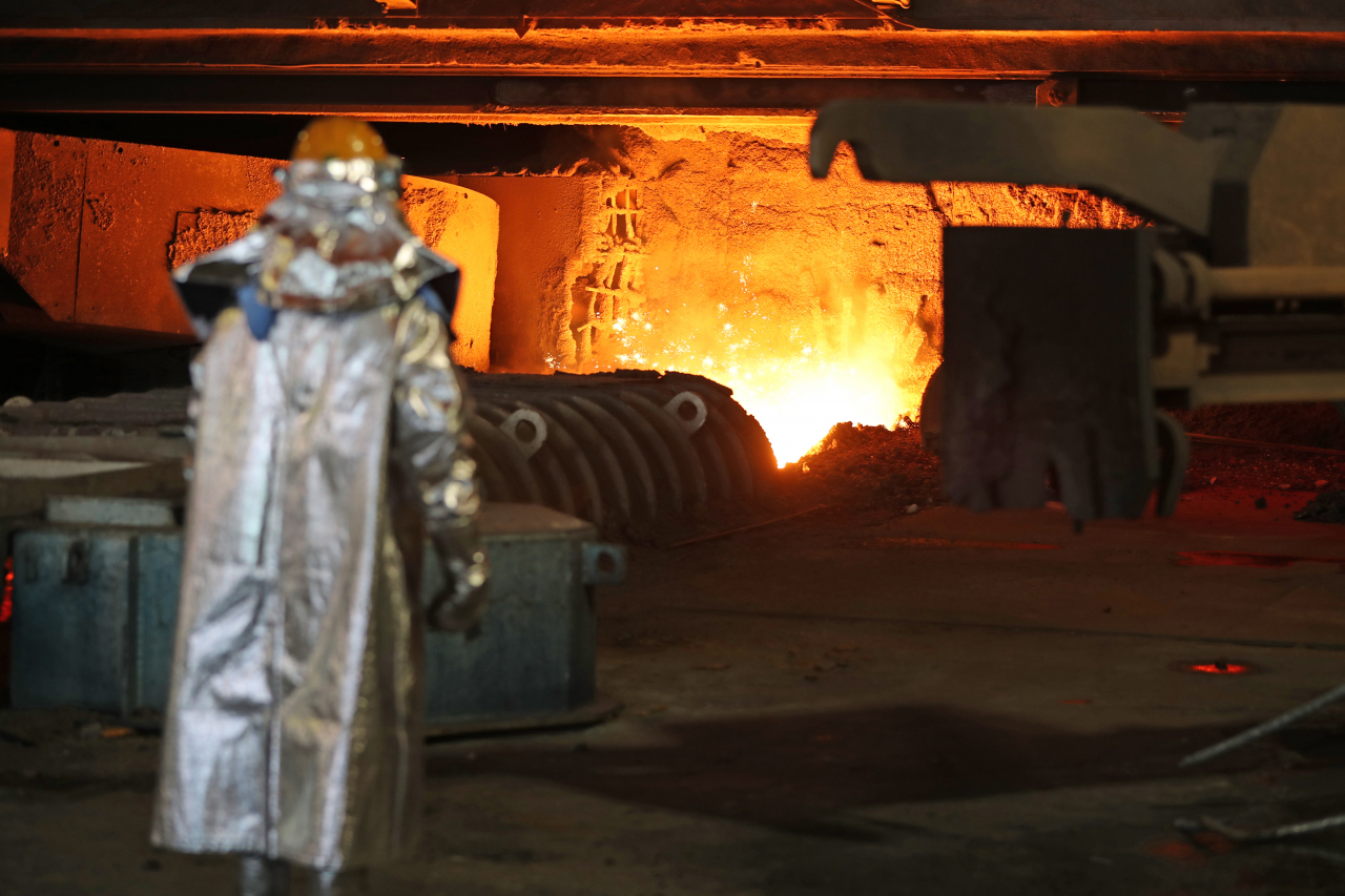 A Posco worker is seen nearby a blast furnace releasing molten iron at Posco’s steel plant in Pohang, North Gyeongsang Province. (Yonhap)
