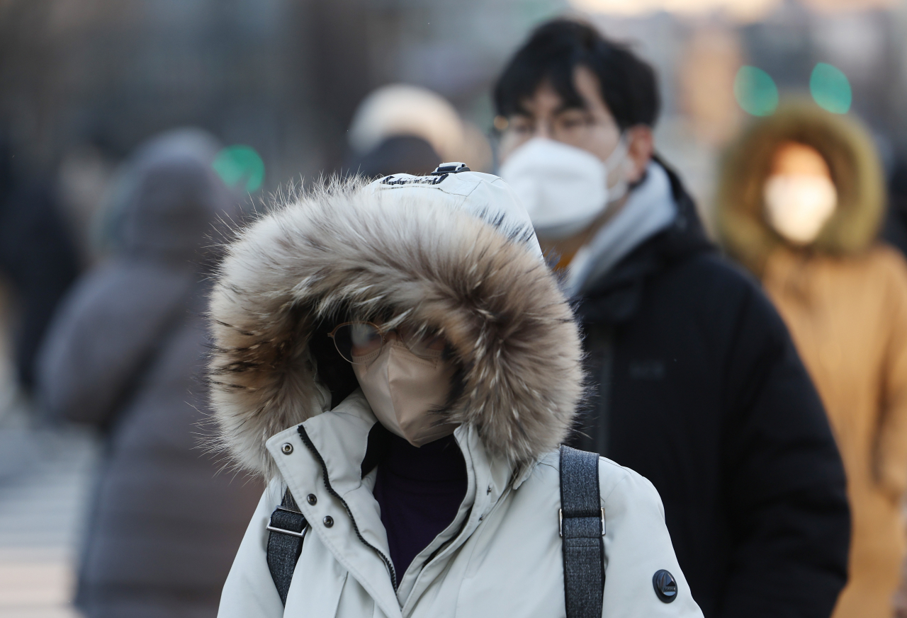 두꺼운 옷차림을 한 출근길 시민들이 광화문네거리를 지나고 있다. [연합]
