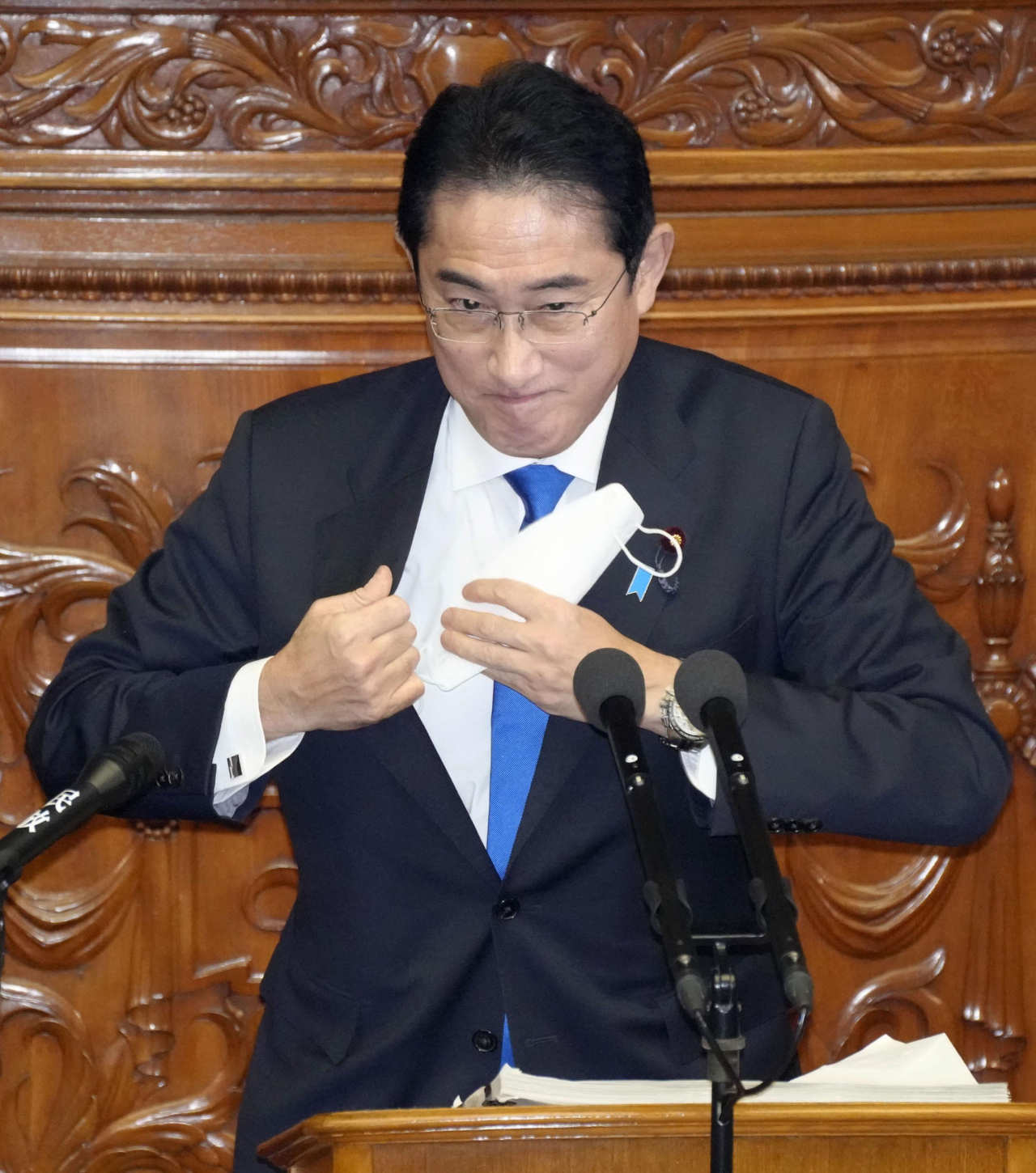 기시다 후미오 일본 총리가 23일 국회 본회의장에서 연단에 오른 뒤 정기국회 시정방침 연설을 위해 마스크를 안주머니에 넣고 있다. [연합]