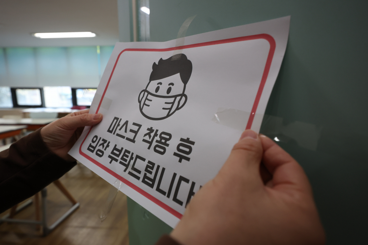 29일 오후 대구 수성구 한 영어학원에서 직원이 실내 마스크 착용 안내문을 떼고 있다. 30일부터 의료기관·약국, 교통수단, 감염취약시설을 제외하고는 실내마스크 착용 의무가 해제됐다[연합]