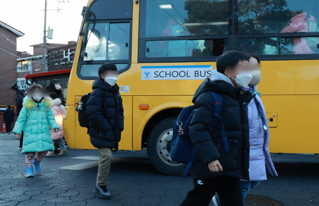 학교, 마트 등 실내마스크 착용 의무가 해제된 30일 서울 광진구 광장초등학교 앞에서 통학버스를 이용하는 학생들이 마스크를 착용한 채 하차해 교실로 향하고 있다. [연합]