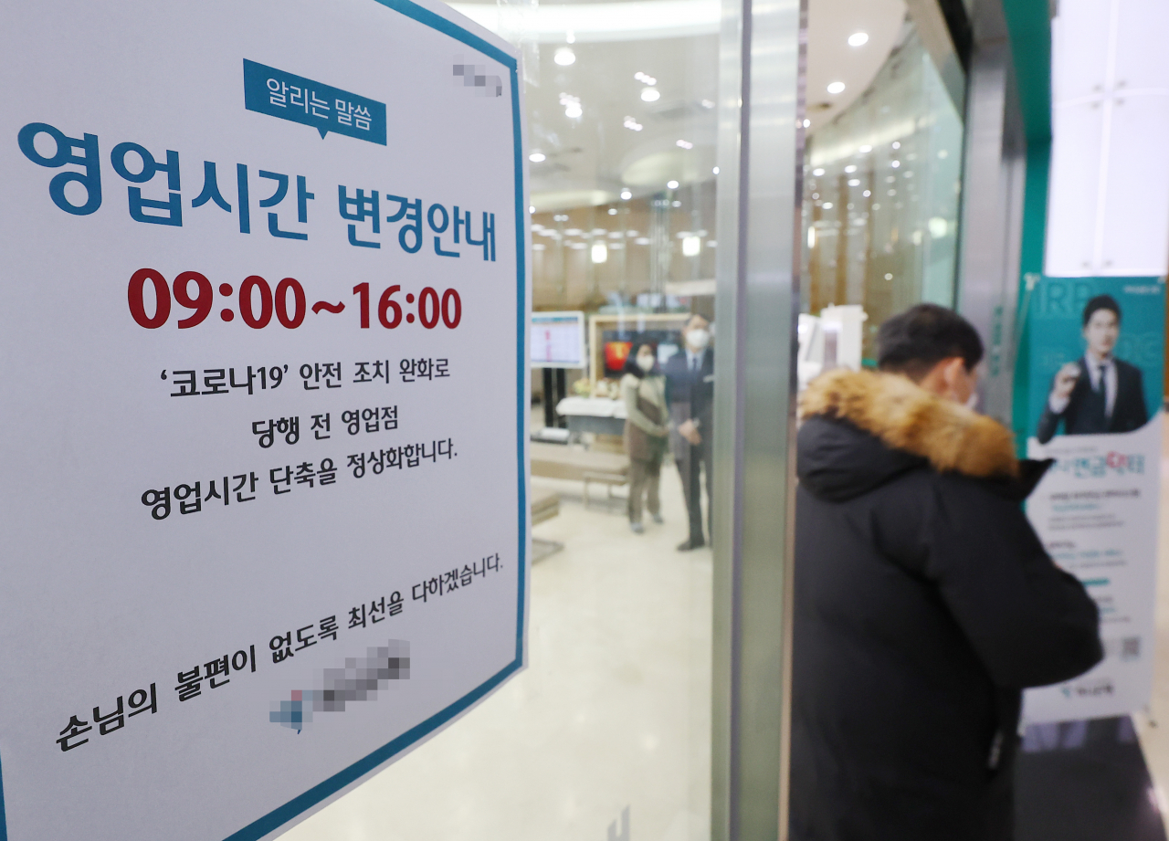 주요 시중은행과 저축은행들이 약 1년 반 만에 단축 영업을 끝내고 영업시간 정상화에 돌입한 30일 오전 서울 시내의 한 은행에서 고객이 기존 개장 시간 9시30분 보다 이전에 업무를 마치고 객장을 나서고 있다. [연합]