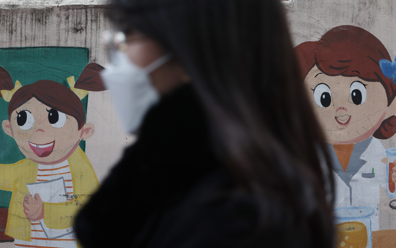 사진은 기사 내용과 무관. 29일 성동구의 한 마을 벽화 속 웃는 얼굴에 누군가가 검정색 펜으로 그려놓은 마스크가 눈에 띈다. 코로나19 방역조치로 지난 2020년 10월부터 유지되어 온 마스크 착용 의무 조치가 해제되는 오는 30일부터는 대중교통, 병원 등 일부 시설을 제외하곤 실내에서도 마스크를 쓰지 않아도 된다. [연합]