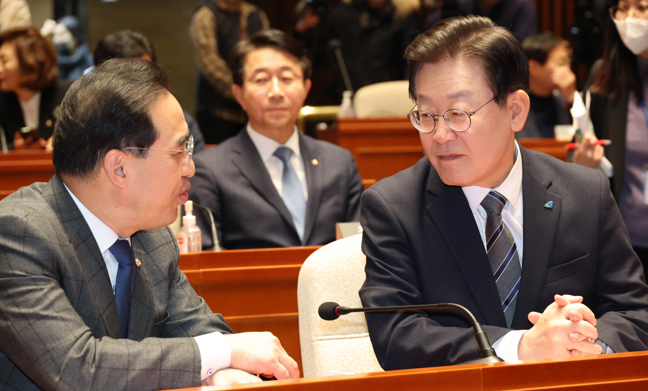 더불어민주당 이재명 대표와 박홍근 원내대표가 30일 국회에서 열린 의원총회에서 대화하고 있다. [연합]