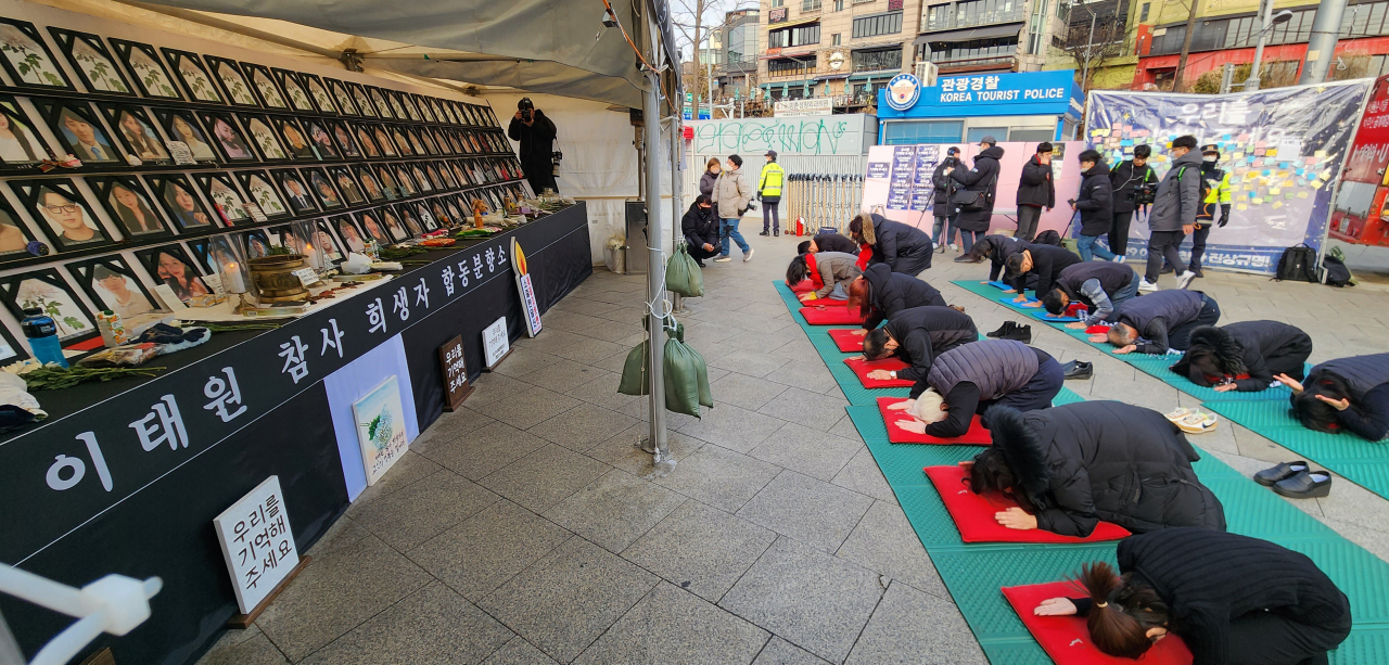 Bereaved families of Itaewon disaster victims and the civic group members bow for the 159 victims at the Itaewon memorial altar, Tuesday. (Yonhap)