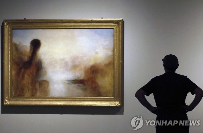 윌리엄 터너의 작품 앞의 관람객이 2022년 5월 19일(현지시간) 스페인 바르셀로나의 미술관에 전시된 영국 화가 윌리엄 터너의 작품을 보고 있다. [EPA 연합]