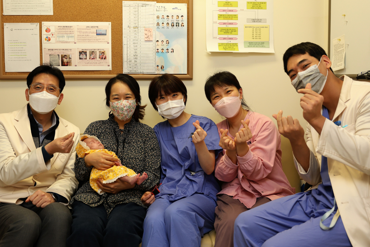 삼성서울병원은 최근 몸무게 1.1kg인 아기 윤슬이를 대상으로 동맥관개존증 비수술적 폐쇄술에 성공해 국내에서 이 분야 최소 체중 기록을 경신했다고 밝혔다. 윤슬이의 퇴원을 앞두고 의료진들이 축하해 주고 있다. 사진 왼쪽부터 송진영 삼성서울병원 소아청소년과 교수, 윤슬이를 안고 있는 엄마 김노을씨