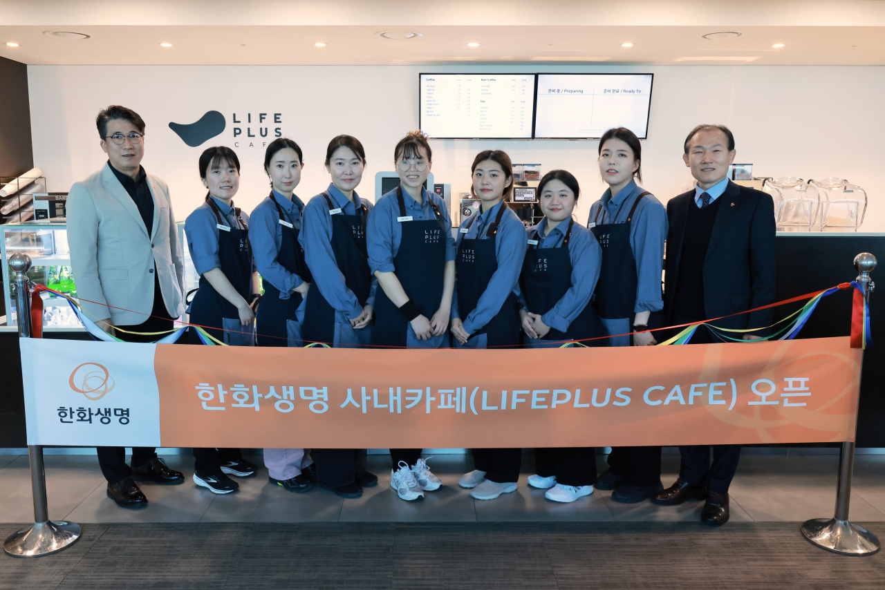 한화생명이 1일 서울 여의도 63빌딩에 문을 연 LIFEPLUS 카페 개소식에서 이원근 한화생명 이원근 경영지원팀장(맨 왼쪽), 김진철 장애인고용공단 서울남부지사장(맨 오른쪽), 장애인 바리스타 등 관계자들이 기념촬영을 하고 있다. [한화생명 제공]