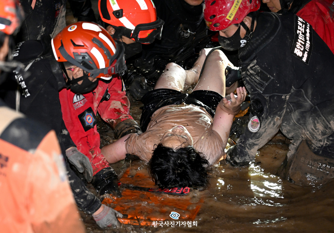〈최우수상 - 15시간 고립, 기적의 생존자〉 슈퍼 태풍 '힌남노'가 9월 6일 오전 4시 50분 경남 거제 부근으로 상륙해 부산을 거쳐 오전 7시 10분쯤 울산 앞바다를 통해 동해로 빠져나간 과정에서 경북 포항과 경주 등 영남 해안지역에 집중호우가 쏟아져 곳곳이 침수되면서 인명과 재산 피해가 속출했다.피해가 가장 컸던 포항에서는 남구 인덕동에 위치한 한 아파트의 주차장이 침수되자 주민들이 차를 빼러 갔다가 6명이 사망하는 안타까운 사고가 발생한 가운데 30대와 50대 남녀 2명이 생존 상태로 구조됐다. 이들은 침수된 지하 주차장 내 호흡이 가능한 공간에서 13, 15시간 씩을 버티며 살아날 수 있었다. 6일 저녁 9시 47분 침수된 지하주차장에서 김모(52)씨가 기적적으로 구조되고 있다. 〈서재훈 기자 / 한국일보 / 한국사진기자협회〉