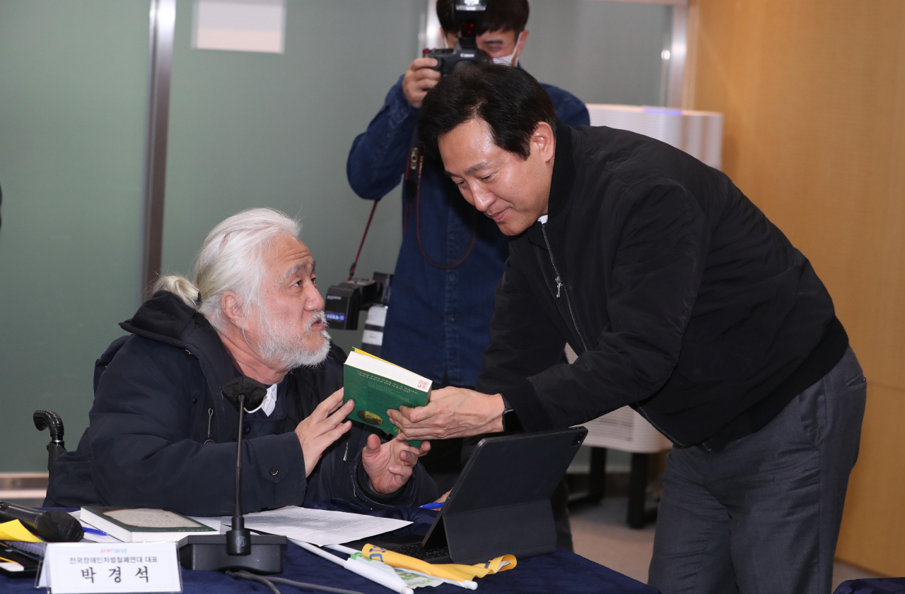 2일 서울시청에서 오세훈 시장이 전국장애인차별철폐연대와 면담 중 박경석 대표에게 자료를 받고 있다. [연합]