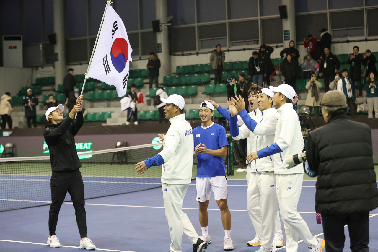 한국이 2023 데이비스컵 최종본선 진출전에서 벨기에를 꺾고 16강에 오른 뒤 태극기를 휘두르며 기뻐하고 있다./연합뉴스