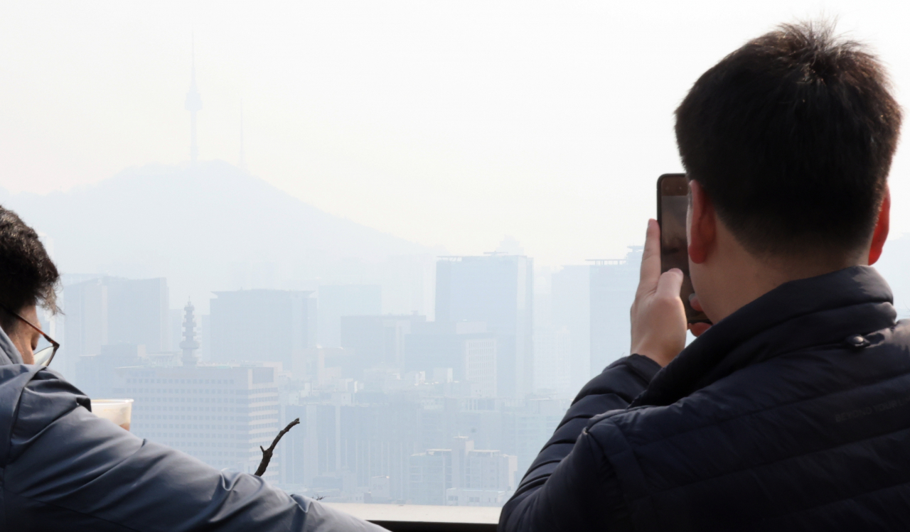 미세먼지 나쁨을 기록한 5일 인왕산에서 시민들이 서울 시내를 보고 있다. [연합]