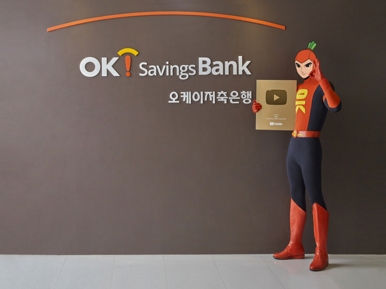 OK금융그룹의 대표 캐릭터인 읏맨이 골드버튼을 들고 있는 모습. [사진=OK금융그룹]