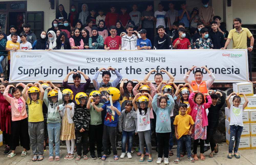 KB손해보험이 지난 6일 인도네시아 보고르 소재 RLC(Refugee Learning Center) 학교에서 안전한 이륜차 운행을 위한 안전모 1200개를 전달하고 기념사진을 촬영하고 있다. [KB손해보험 제공]