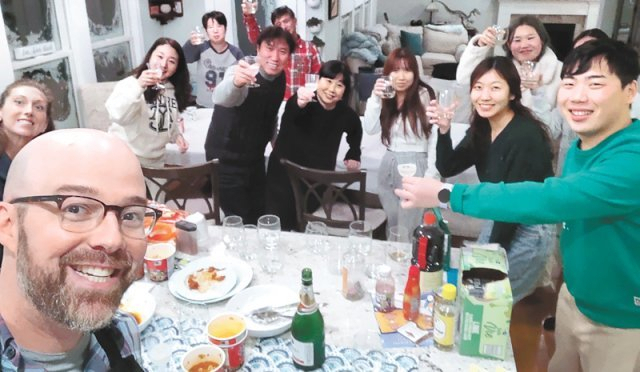 미국에 폭설이 쏟아졌던 지난달 24일(현지시간) 미국 뉴욕주 버펄로에 사는 알렉산더 캠파냐(앞줄 왼쪽) 씨와 부인 앤드리아(캠파냐 씨 바로 뒤) 씨가 최요셉(오른쪽) 씨를 비롯해 눈길에 발이 묶인 한국인 관광객들을 집으로 불러들여 같이 식사하며 건배하고 있다. [알렉산더 캠파냐 씨 페이스북 캡처]