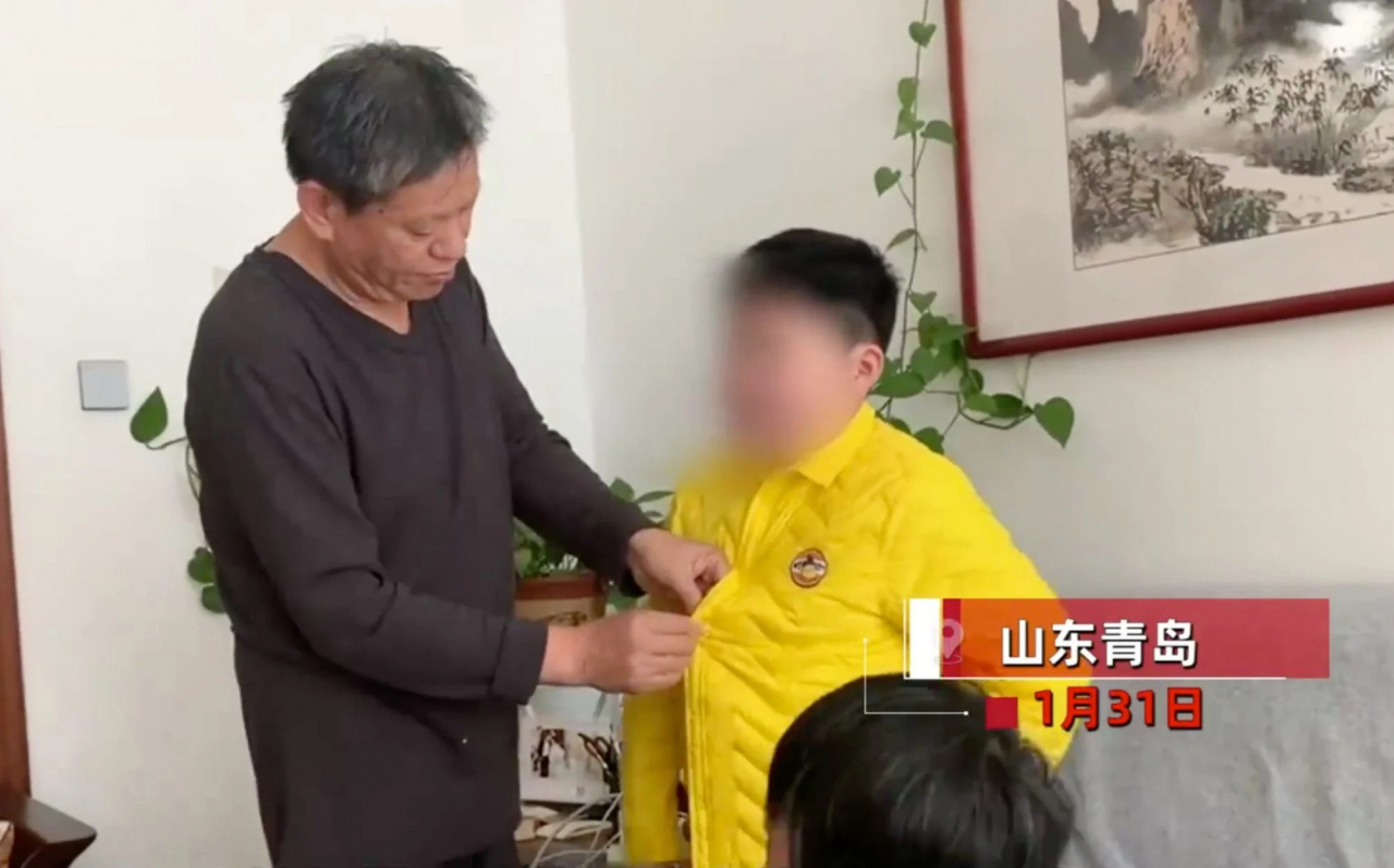 할아버지가 10살짜리 외손주 옷을 직접 입혀주고 있는 모습.[바이두 캡쳐]
