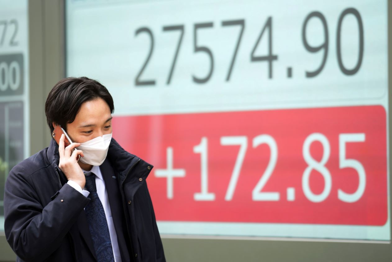 일본의 한 회사원이 도쿄에 있는 증권사 앞을 지나가고 있다. [AP=연합]