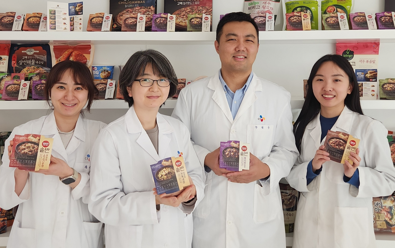 CJ제일제당 식품연구소 쌀·곡물(Rice·Grain) 카테고리팀 연구원들이 ‘햇반 솥반’을 들고 포즈를 취하고 있다. 왼쪽부터 김은혜, 오예진, 장일상, 박형선 연구원. [CJ제일제당 제공]