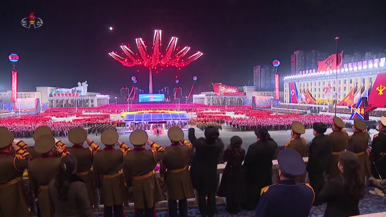 북한이 건군절(인민군 창건일) 75주년인 지난 8일 평양 김일성광장에서 열병식을 개최하는 영상을 조선중앙TV가 9일 방송했다. 사진은 김정은 위원장이 서 있는 열병식 주석단 위로 컬러 연막을 내뿜으며 날아가는 북한 항공기들. [연합]