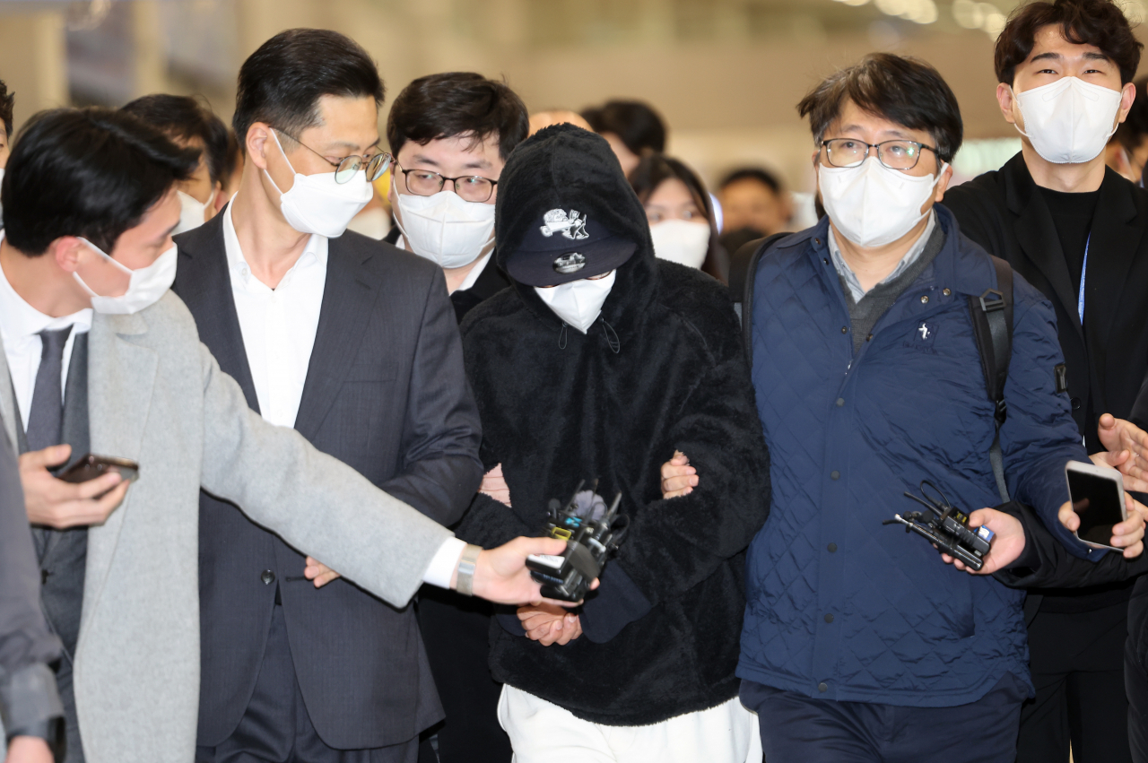 김성태 쌍방울 그룹 전 회장의 금고지기이자 매제인 쌍방울 그룹 전 재경총괄본부장 김모(가운데) 씨가 해외 도피 9개월 만인 11일 오전 인천공항을 통해 입국하고 있다. [연합]