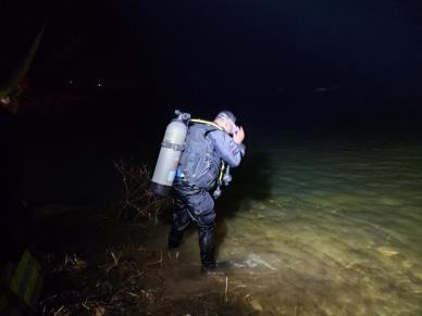 여수소방 돌산119센터 직원이 저수지에 빠진 운전자를 구조하기 위해 접근하고 있다.