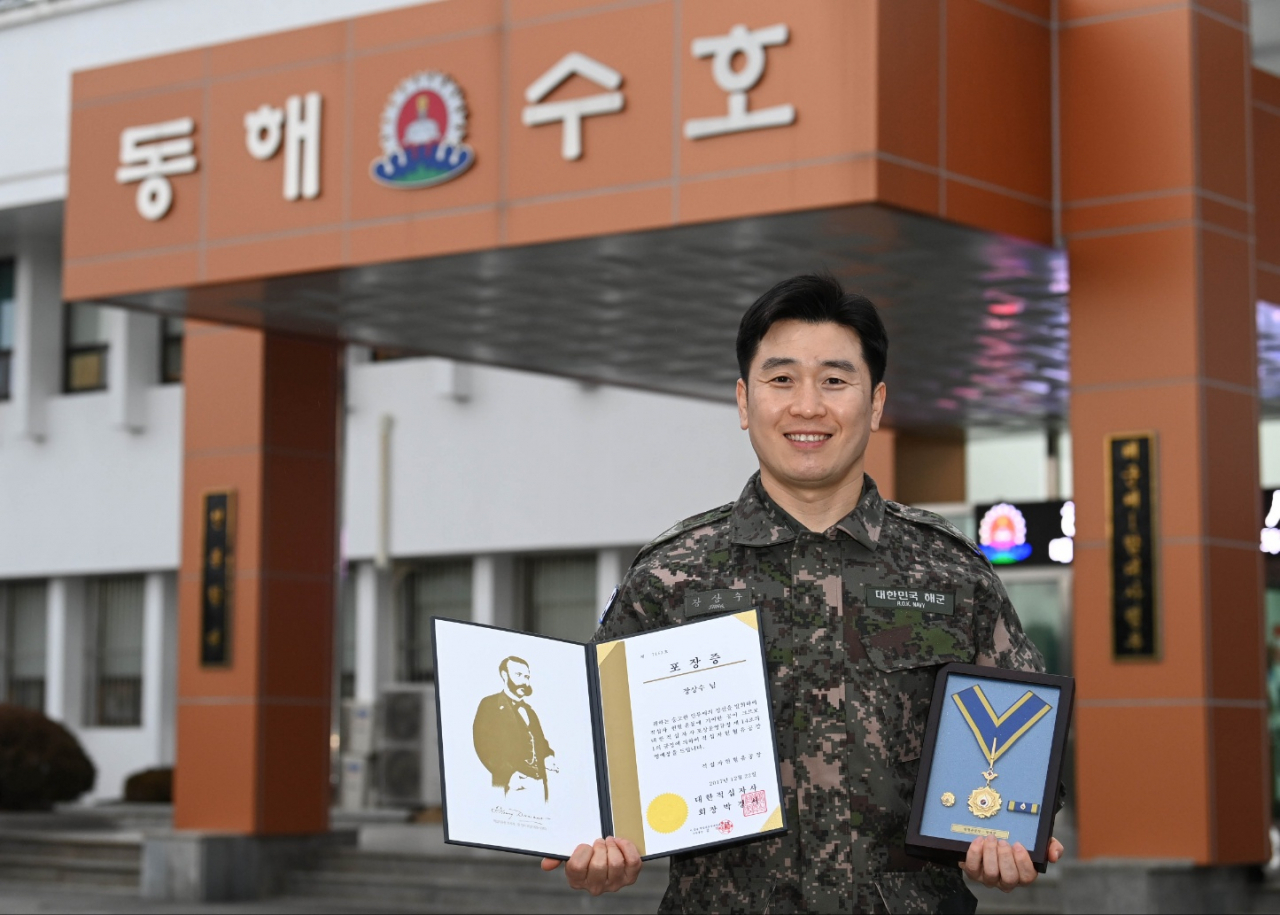 희소 혈액형인 RH- A형을 보유한 해군 1함대사령부 장상수 상사가 대한적십자사로부터 받은 헌혈 100회 명예장과 포장증을 펼쳐 보이고 있다. [해군 제공]