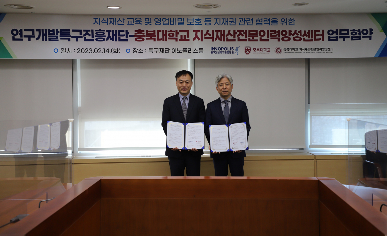 이형택(왼쪽) 충북대 지식재산전문인력양성센터장과 홍순규 특구진흥재단 과학벨트지원본부장이 업무협약서를 들어 보이고 있다.[특구진흥재단 제공]