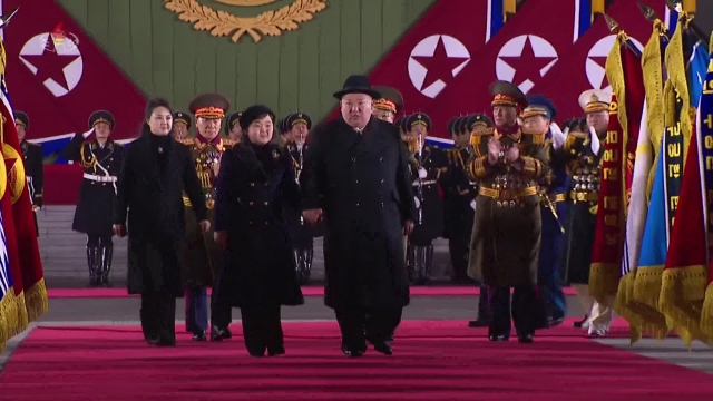 조선중앙TV는 9일 전날 밤 열린 인민군 창건일(건군절) 75주년 기념 열병식을 녹화중계했다. 사진은 김정은 국무위원장이 딸 김주애의 손을 잡고 레드카펫을 지나며 주요부대 군기를 사열하는 모습. 뒷편에 김 위원장의 부인 리설주 여사가 뒤따르고 있다. [연합]