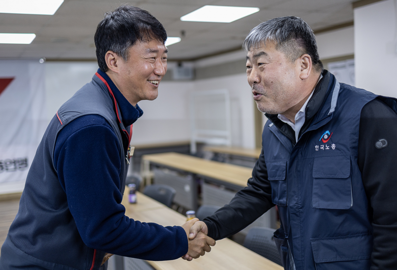 양경수 전국민주노동조합총연맹 위원장(왼쪽)과 김동명 한국노동조합총연맹 위원장이 15일 오전 서울 민주노총 교육장에서 열린 간담회에 앞서 악수를 나누고 있다. [연합]