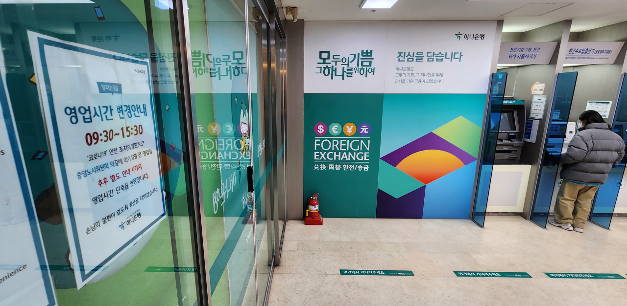 서울 한 시중은행의 출입구에 붙은 영업시간 변경 안내문.[연합]