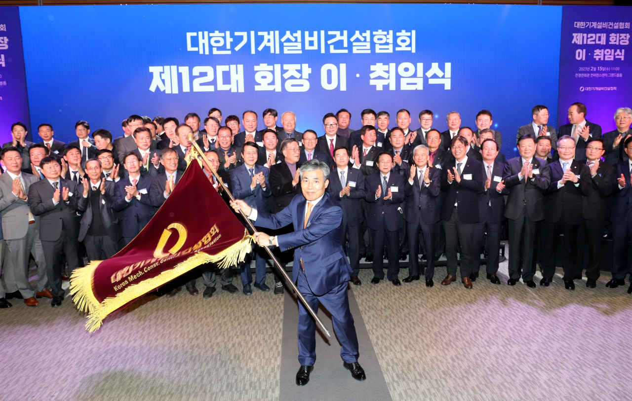 조인호(가운데) 대한기계설비건설협회 신임 회장이 15일 서울 여의도 전경련회관에서 열린 이·취임식에서 협회기를 들고 흔들고 있다. [대한기계설비건설협회 제공]
