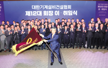 조인호(가운데) 대한기계설비건설협회 신임 회장이 15일 서울 여의도 전경련회관에서 열린 이·취임식에서 협회기를 들고 흔들고 있다. [대한기계설비건설협회 제공]