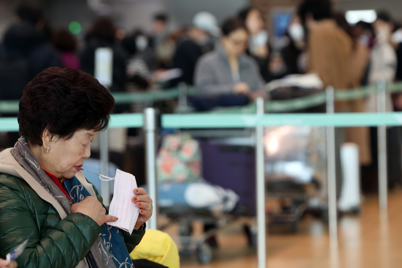 대중교통 수단과 병원 등 일부 시설을 빼곤 실내마스크 착용 의무가 해제된 가운데 31일 오전 인천국제공항에서 한 이용객이 마스크를 만져보고 있다. [연합]