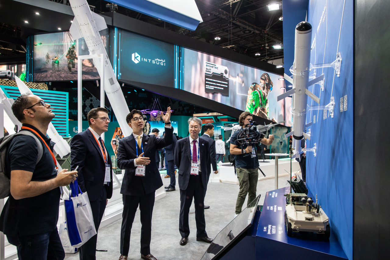 UAE 아부다비 ‘IDEX 2023’ 전시장에 마련된 LIG넥스원 부스를 방문한 관람객들이 회사 관계자로부터 LIG넥스원의 현궁이 탑재된 현대로템 HR-SHERPA 무인차량(모형)에 대한 설명을 듣고 있다. [LIG넥스원 제공]