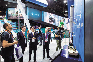 UAE 아부다비 ‘IDEX 2023’전시장에 마련된 LIG넥스원 부스를 방문한 관람객이 회사 관계자로부터 설명을 듣고 있다. [LIG넥스원 제공]
